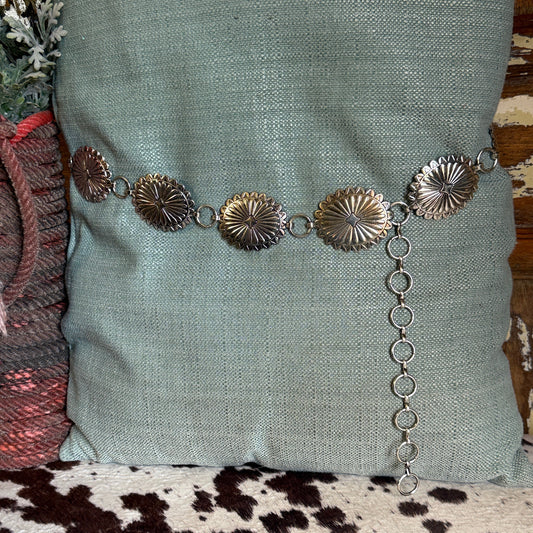 Western concho belt with antiqued silver tone oval scalloped conchos, raised sunburst pattern and chain extender.